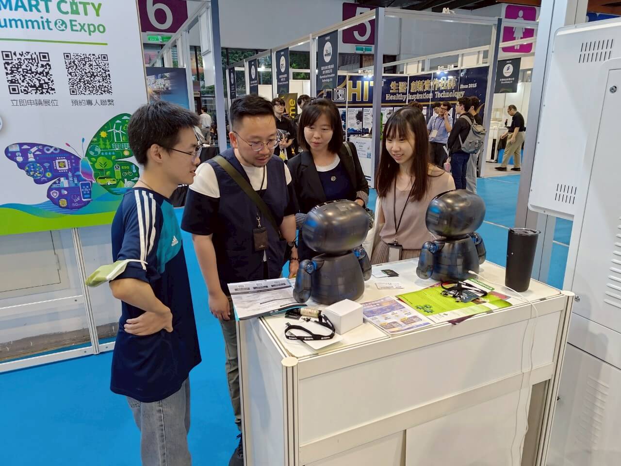AI WAVE SHOW 2025 參觀者圍繞兩台 Kebbi 機器人進行展場交流